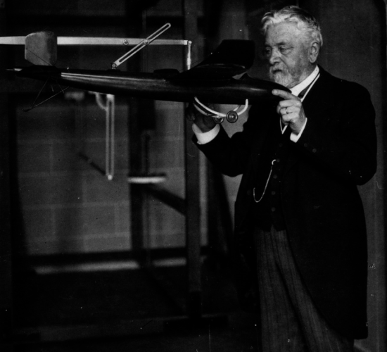 Gustave Eiffel nel suo laboratorio con in mano un modello di aeroplano progettato da Victor Tatin