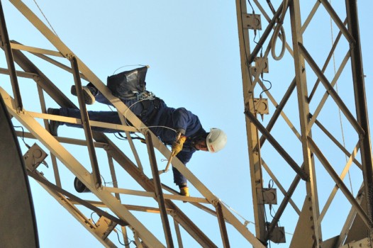 Foto di un addetto alla verniciatura sulla Torre Eiffel