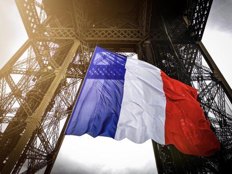 Fotografía de la bandera francesa entre el primer y segundo piso de la Torre Eiffel