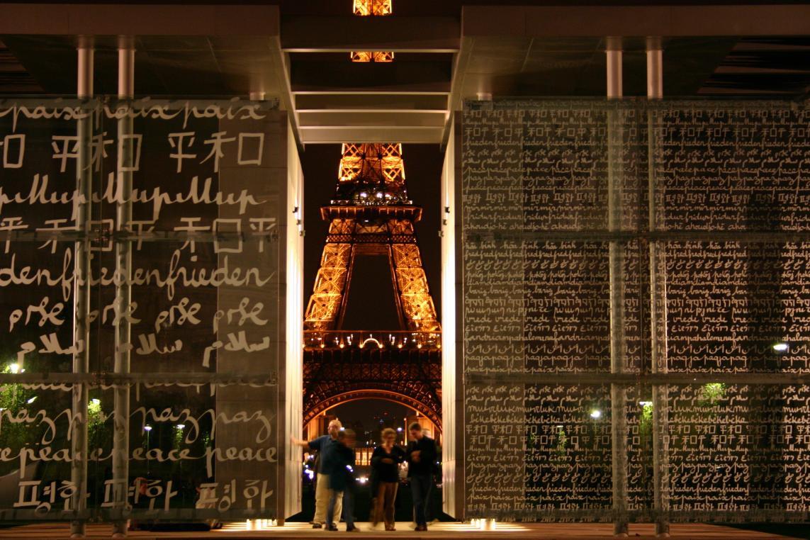 La tour Eiffel de nuit au travers du Mur de la Paix