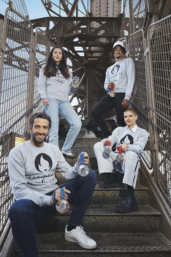 Photo of Tony Estanguet and athletes posing with Olympic medals on the stairs of the Eiffel Tower